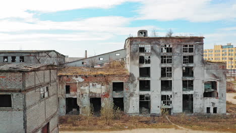 front facade of abandoned building. old factory shows the post industrial plight with broken windows