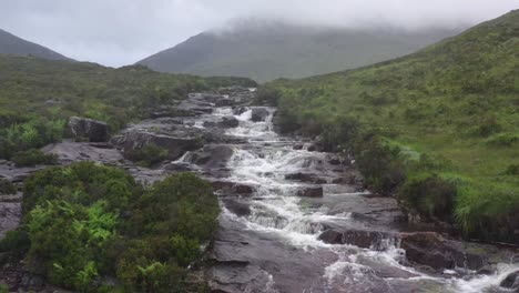 Aerial-View-Of-Water-Cascading-Down-Craggy-Rocks-In-Isle-Of-Skye,-Scotland