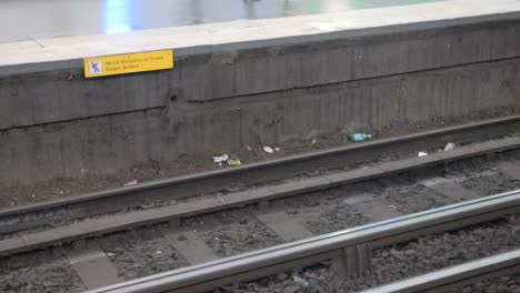 Train-passing-at-high-speed-at-the-station-with-a-lot-of-garbage-in-Paris,-France