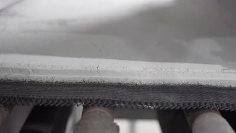 close up shot, stone materials are moving on conveyor belts. the process of converting glass into a stone-like material.