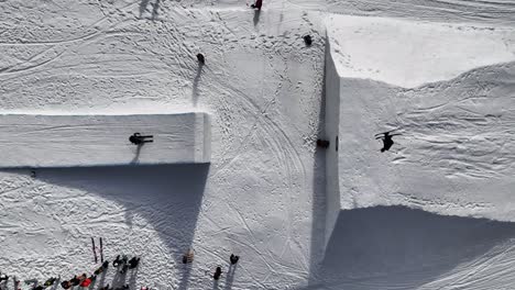 aerial top down view of snowy ramp, skiers jump and perform tricks, czechia