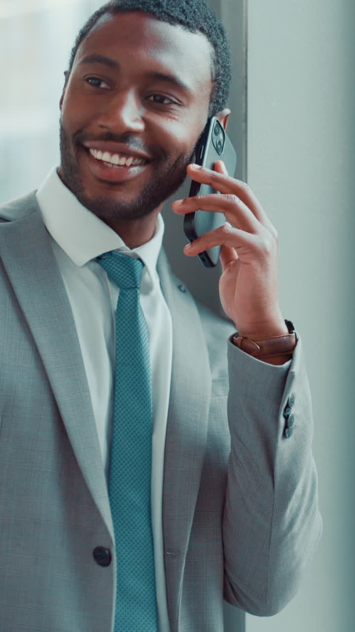 Šťastný podnikatel hovoří na chytrém telefonu v moderní kanceláři