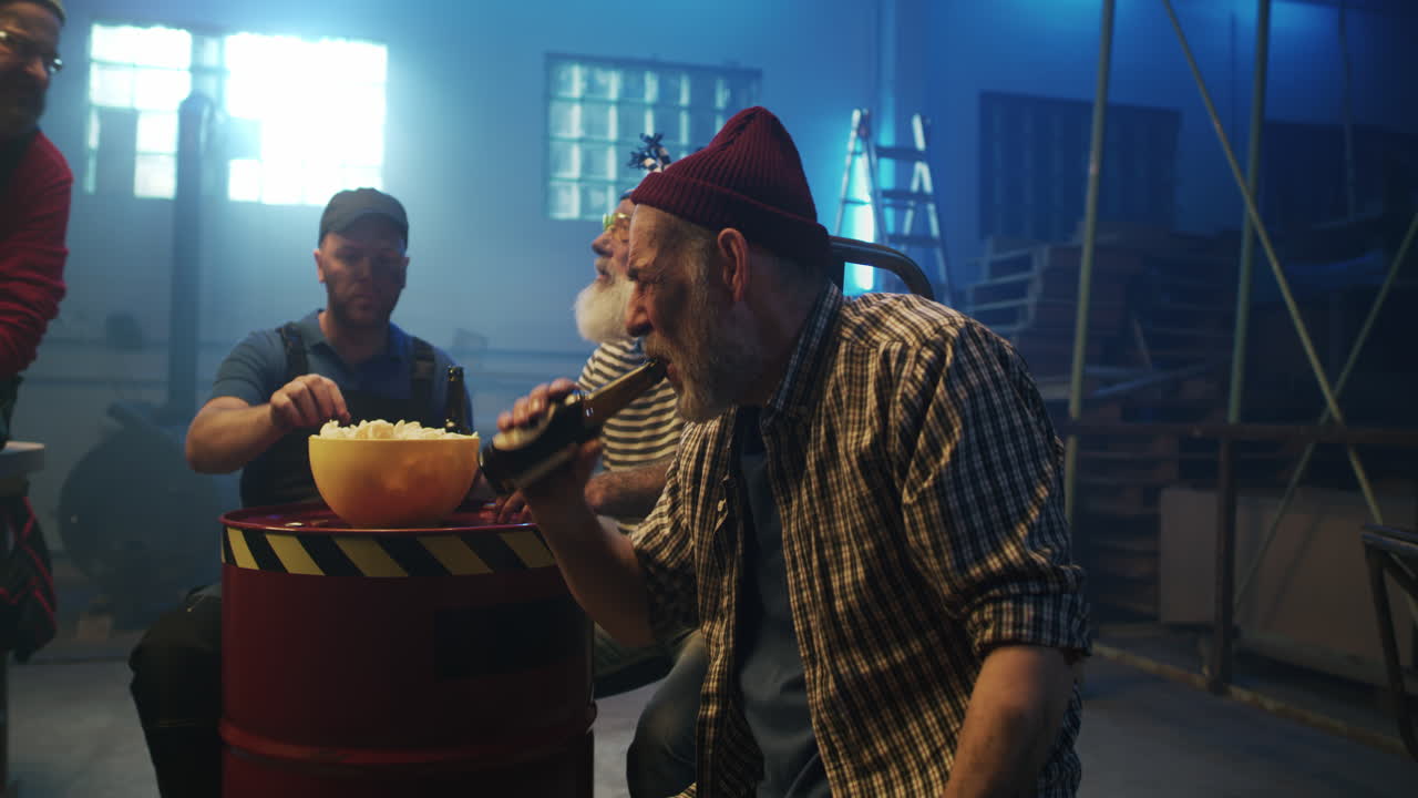 Men Relaxing and Socializing with Popcorn and Beer in a Workshop