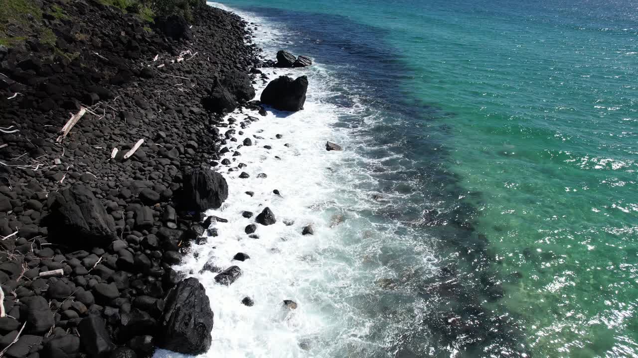 Foamy Waves Rolling Over Rocks On The Coast Of Burleigh Heads In Queensland, Australia. Aerial Closeup Shot