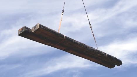 heavy timber beams being lifted by a crane