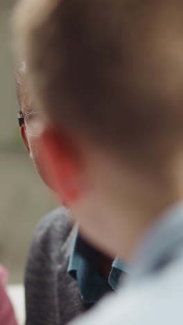 happy african-american teacher with glasses nods praising while listening to student boy answer during english private tuition in living room slow motion