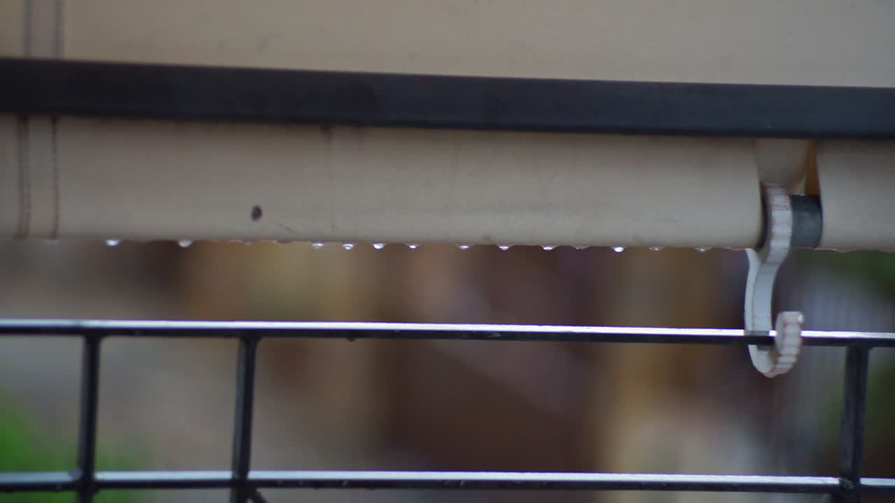 Footage of balcony rail guard with raidrops falling CLOSEUP
