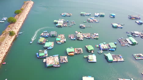 aerial view of a floating fishing village with fish farms and boats