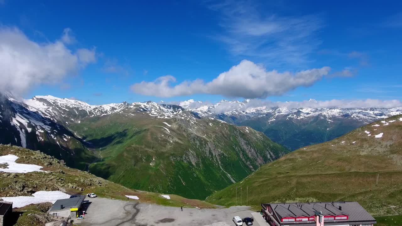 sobrevolando nufenenpass en los alpes suizos a principios del verano con parches de nieve sin derretir