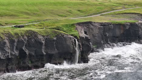 cinematic aerial of waterfall into sea