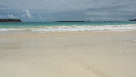 Un-Hermoso-Paisaje-Marino-Tropical-De-Agua-Azul-Clara-De-Las-Bermudas-Y-Olas-Tranquilas-Rompiendo-En-La-Arena