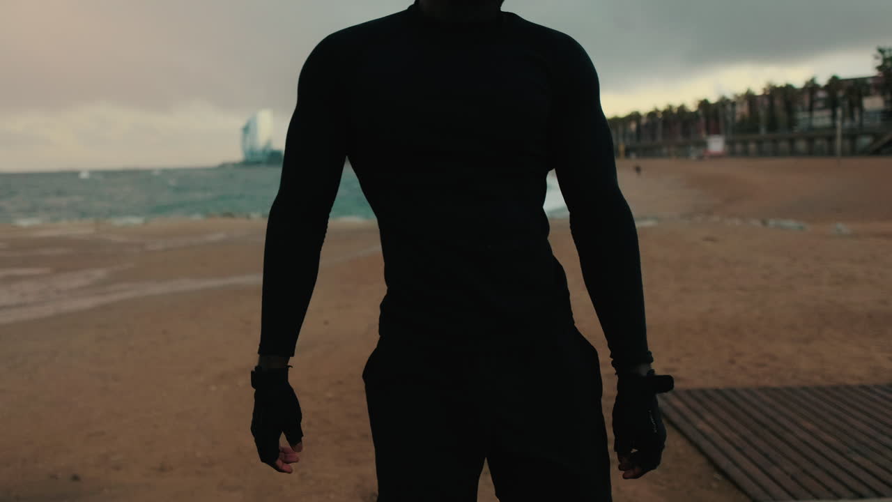 Silhouette of an Athlete Stretching on a Beach at Dawn