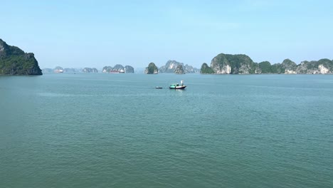 Pequeño-Bote-Que-Pasa-A-Través-De-La-Escena-Abierta-De-La-Bahía-De-Halong,-Vietnam