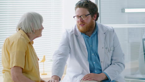 careful doctor supporting elderly woman in clinic