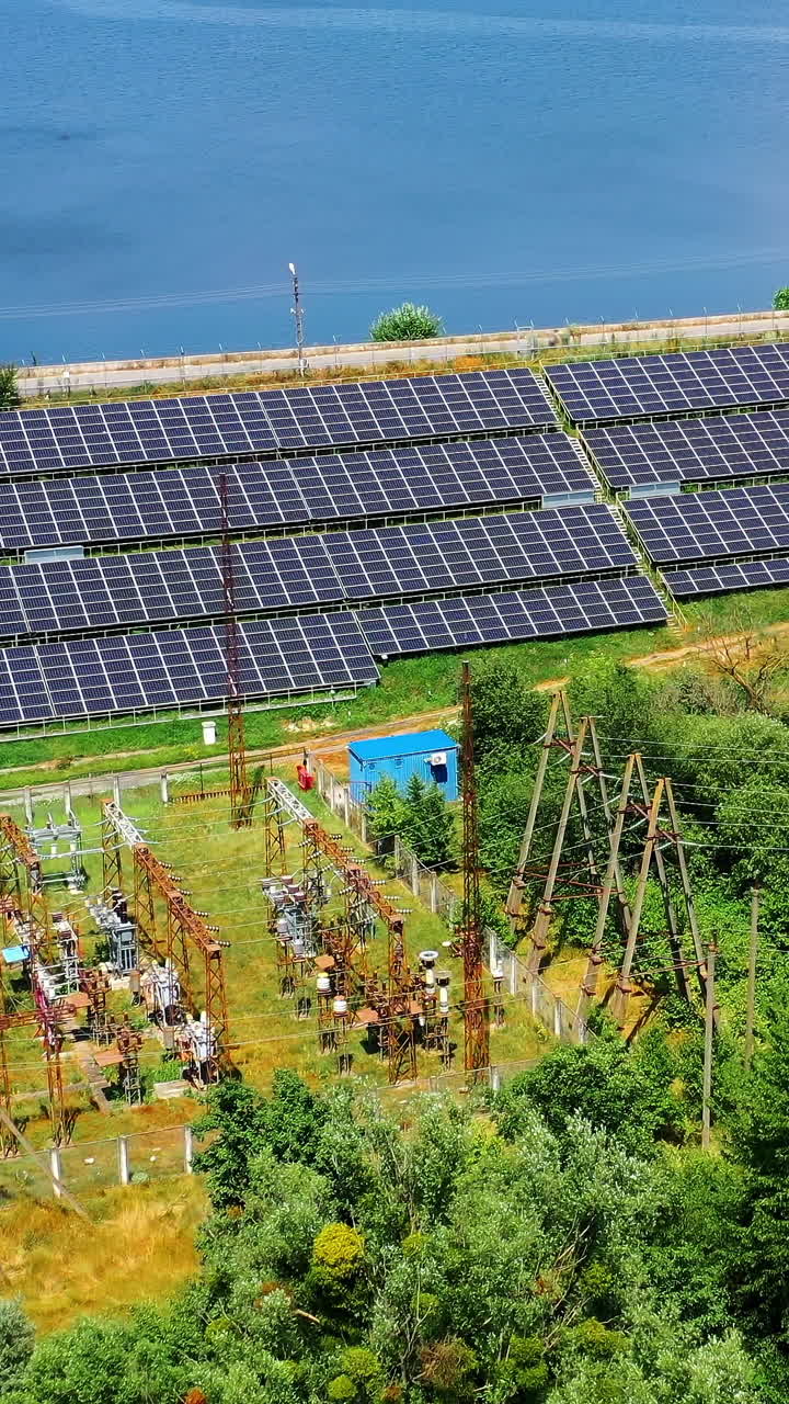 Solar energy farm on sea water background. Blue photovoltaic panels get sunny energy. Renewable source of green eco energy. Aerial view. Vertical video