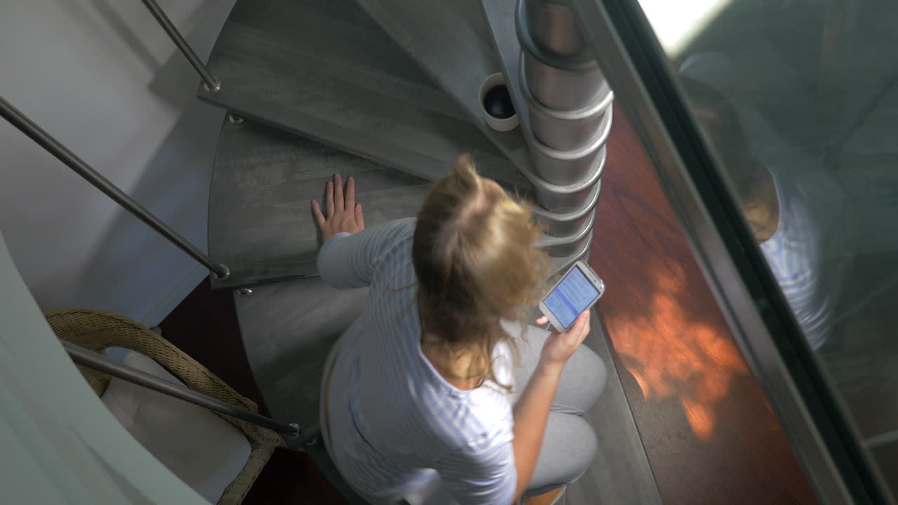 женщина пьет кофе и просматривает мобильный телефон.