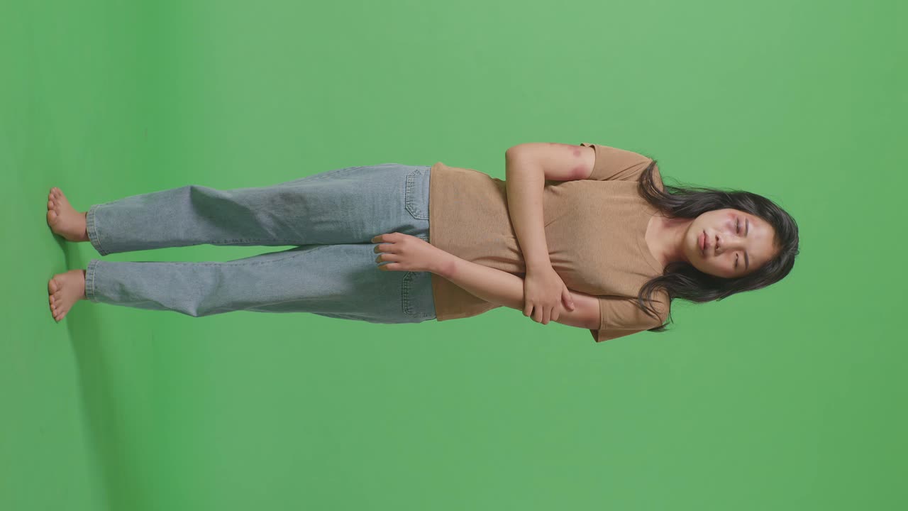 폭력의 희생자였던 젊은 아시아 여성의 몸은 얼굴과 팔에 이 묻어 있었고, 그 이유는 녹색 스크린의 배경 스튜디오에서 신체적으로 학대당했기 때문입니다.