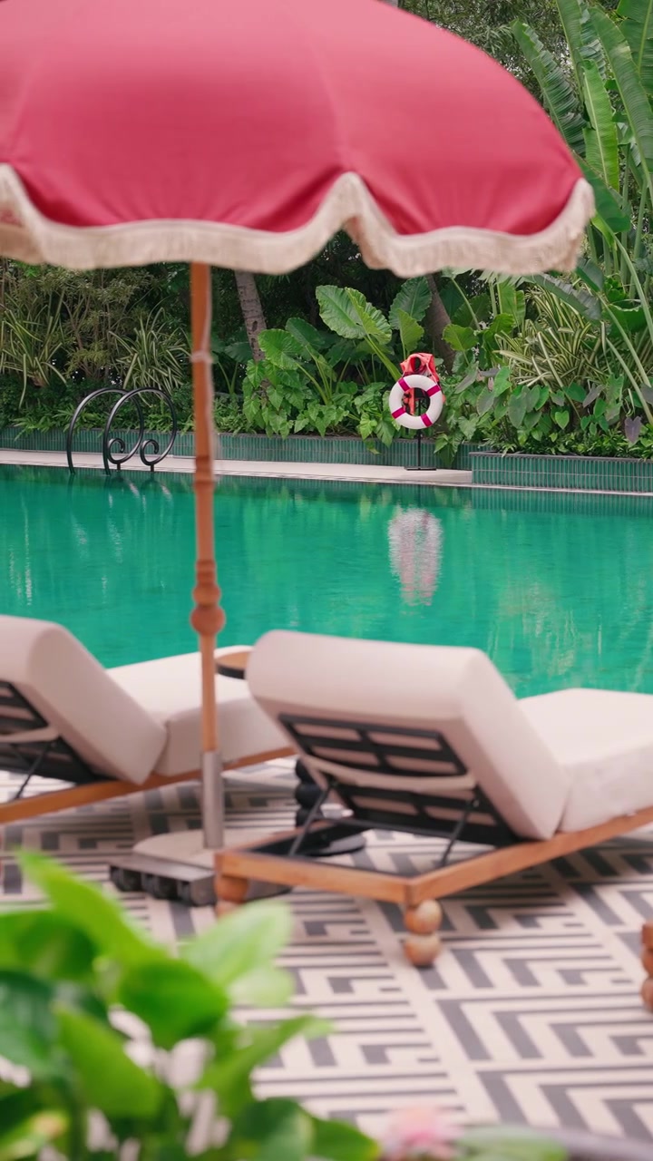 Luxury resort swimming pool with tropical gardens, palm trees, and life preserver. 4k 60fps