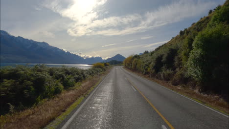 otago, nueva zelanda - viajando a lo largo de una pintoresca carretera a la orilla del lago en el camino a glenorchy - pov