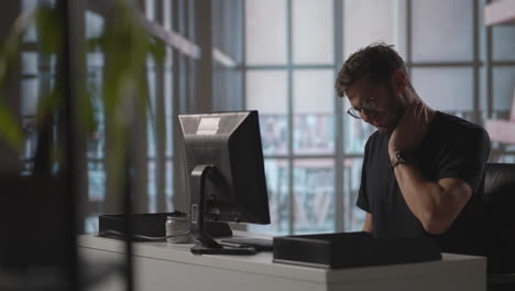 tired businessman having neck pain in office. businessman in casual suit working and suffering with shoulder and neck pain in front of computer business health and office syndrome concept