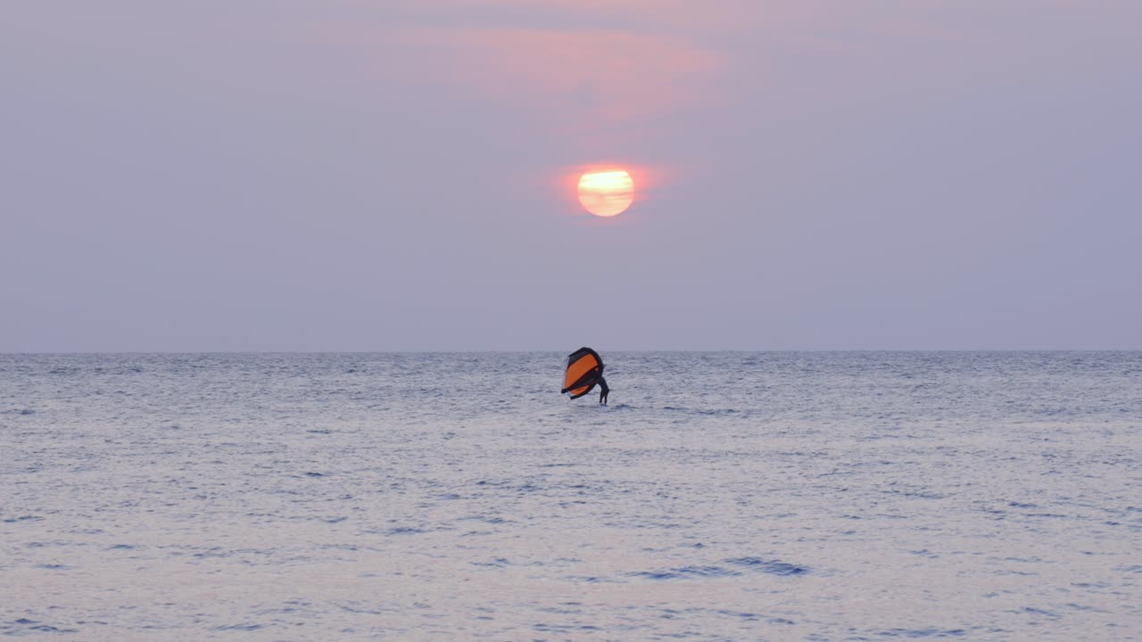 Kitesurfing water sport sailing using wind power at sunset Caribbean Sea coast Colombia