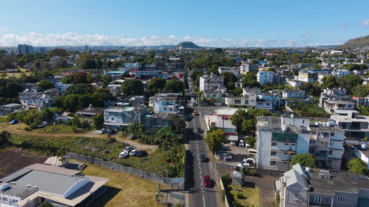 Aerial drone view of Beau Bassin–Rose Hill, Mauritius, showing a suburban neighborhood with residential houses, narrow streets, and tropical greenery under a bright sunny sky
