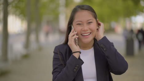 excited young woman talking by cell phone outdoor