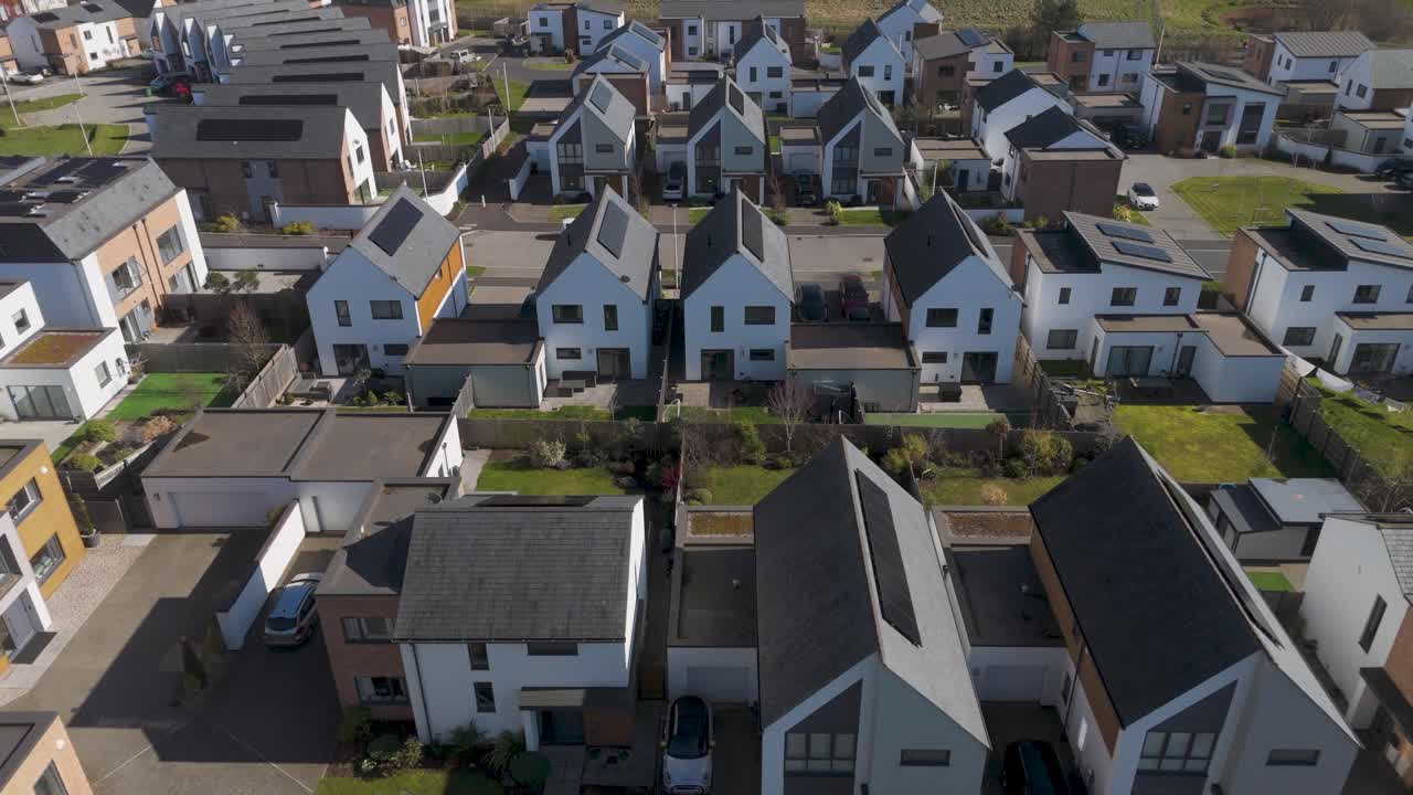 Overhead view of luxury detached homes with angled solar roofs, neat hedges and clean roadway grid highlighting premium energy-smart neighbourhood design