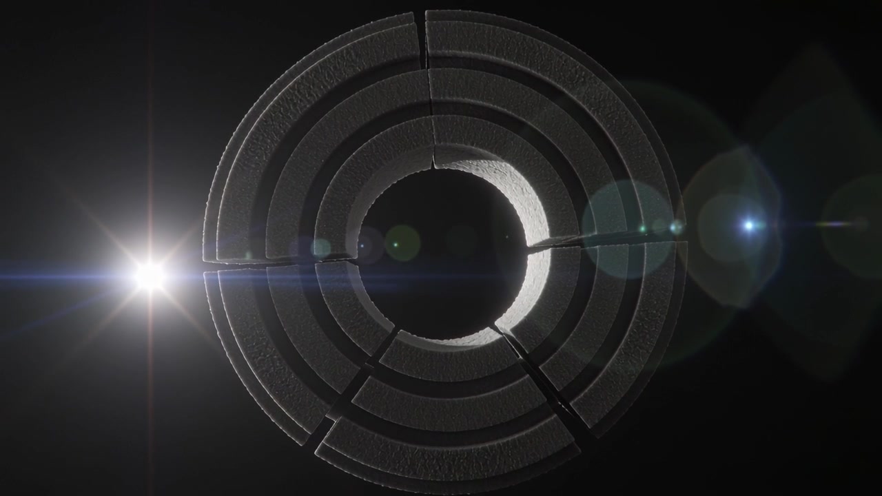 Rotating concentric metal ring showing detail in void, left light causing flare and camera zooming