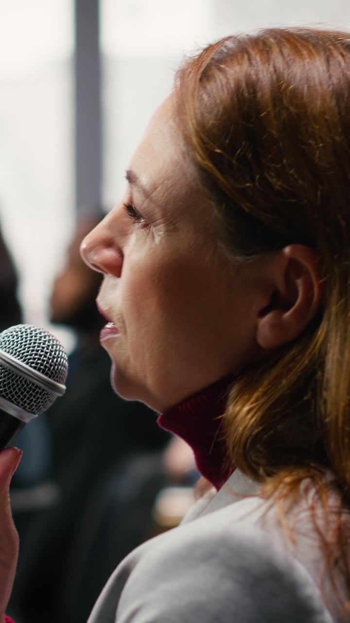 Video verticale di una donna d'affari che alza la mano, pone domande e partecipa a un dibattito