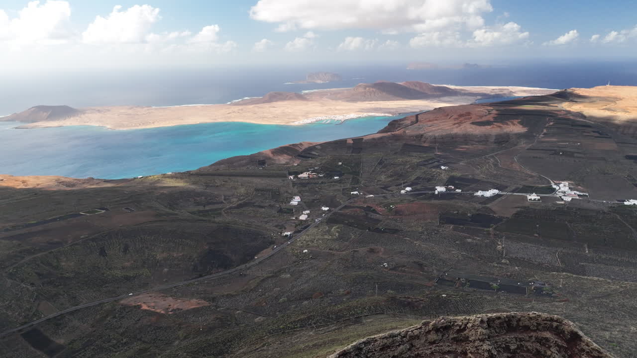 volcán masivo con vistas a la isla de la graciosa y tierras de cultivo cerca de los acantilados de famara