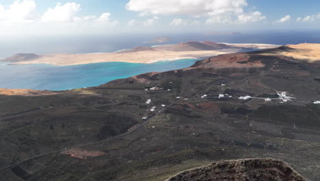 massive vulcan with view to la graciosa island and farmland near famara cliffs