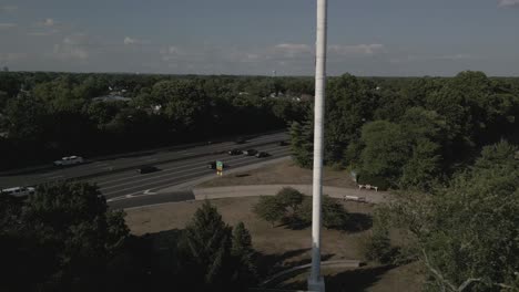 an aerial view of an american flag blowing in the wind in a park on a beautiful day