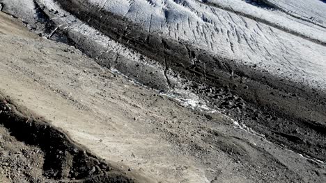 Aerial-flyover-over-Pers-glacier-near-Diavolezza-in-Engadin-Switzerland-with-a-pan-up-from-the-moraine-over-the-crevasses-up-to-Piz-Bernina