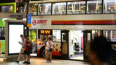 singapore night bus scene: passengers boarding a double decker bus