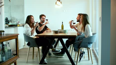 Smiling-friends-clinking-glasses-with-red-wine