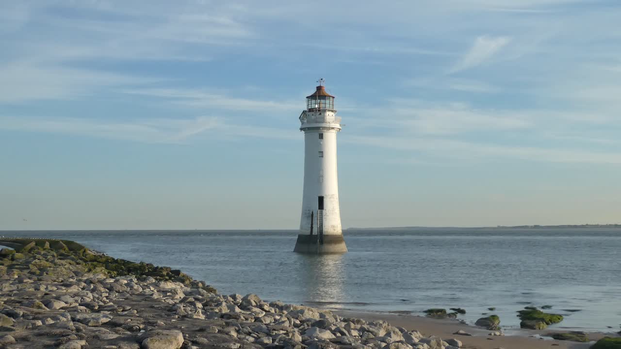 reflejos del faro de la marea baja en la costa británica en la costa rocosa del océano