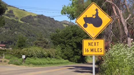 road sign indicates there are farmers with tractors for the next 16 miles in this rural agricultural area