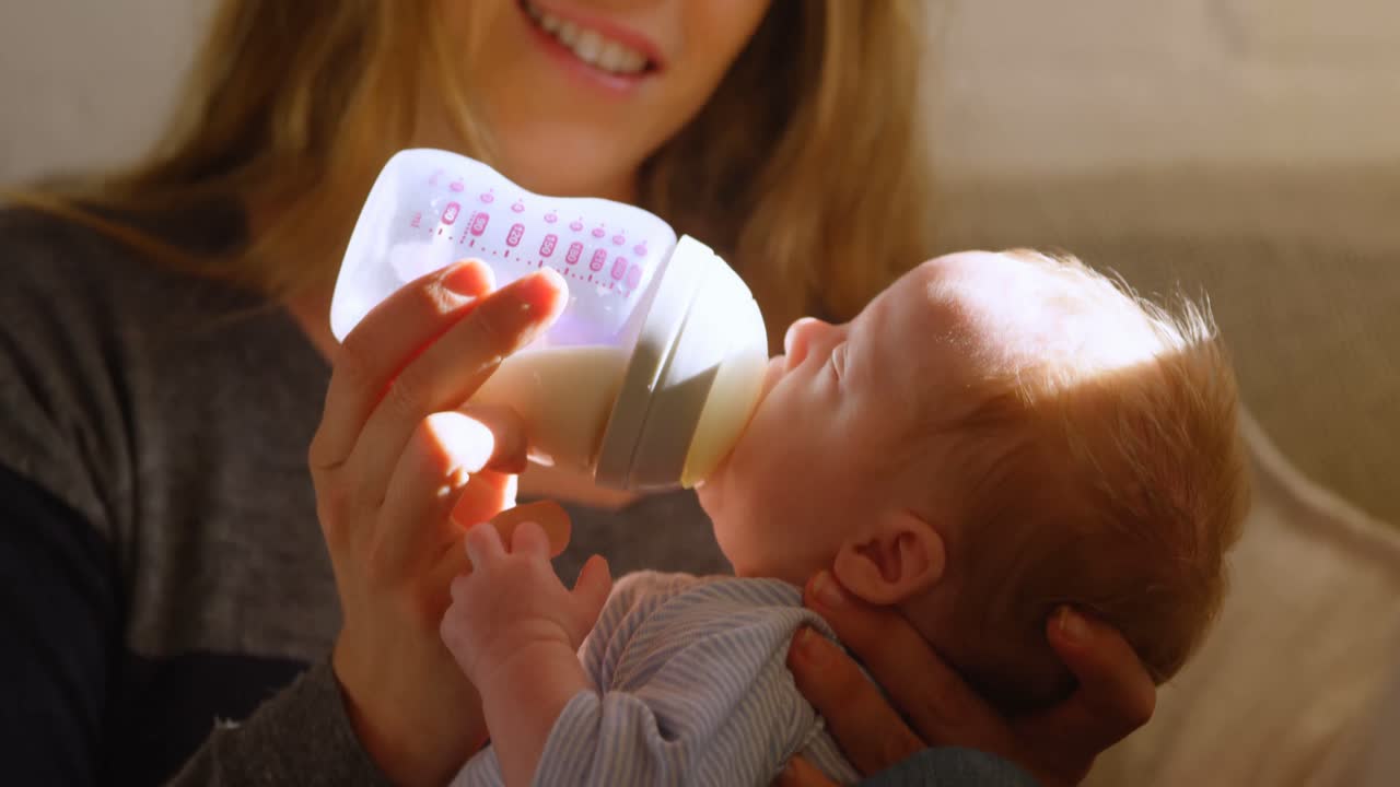madre alimentando con leche a su bebé 4k