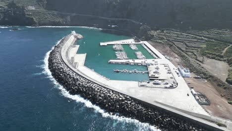 aerial establishing view of large breakwater protecting port of garachico, tenerife