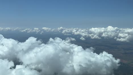 stunning view from a jet cabin: flying across a sky with some tiny cumulus white clouds