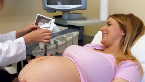 Arzt-Zeigt-Einer-Schwangeren-Frau-Ihre-Ultraschalluntersuchung