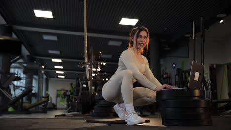woman working out in a gym with a laptop