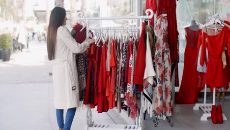 Mujer-Joven-En-Busca-De-Un-Colorido-Vestido-Rojo