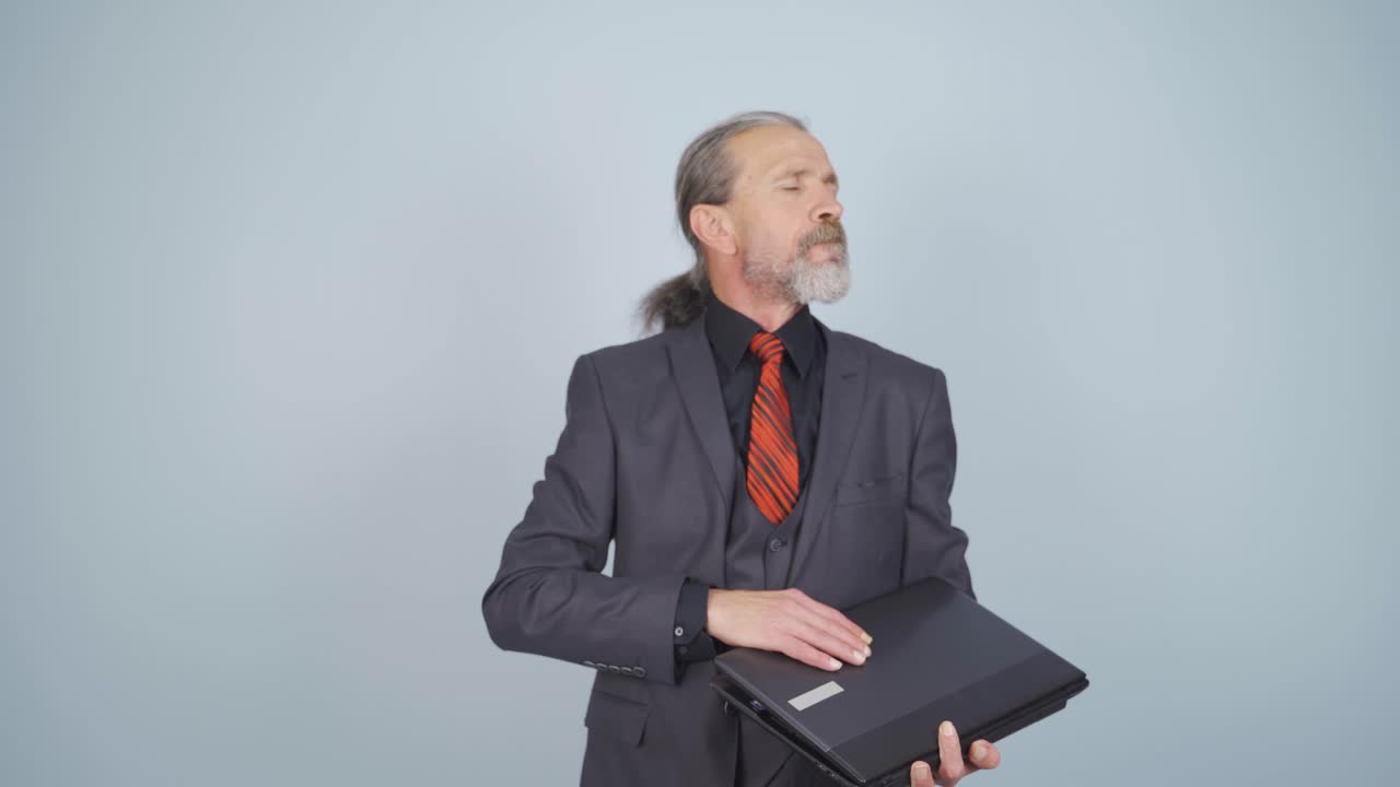 un hombre de negocios enojado cierra su computadora portátil enojado.