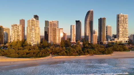 golden morning light bathes gold coast skyscrapers and beach, highlighting urban and natural beauty in a serene coastal setting