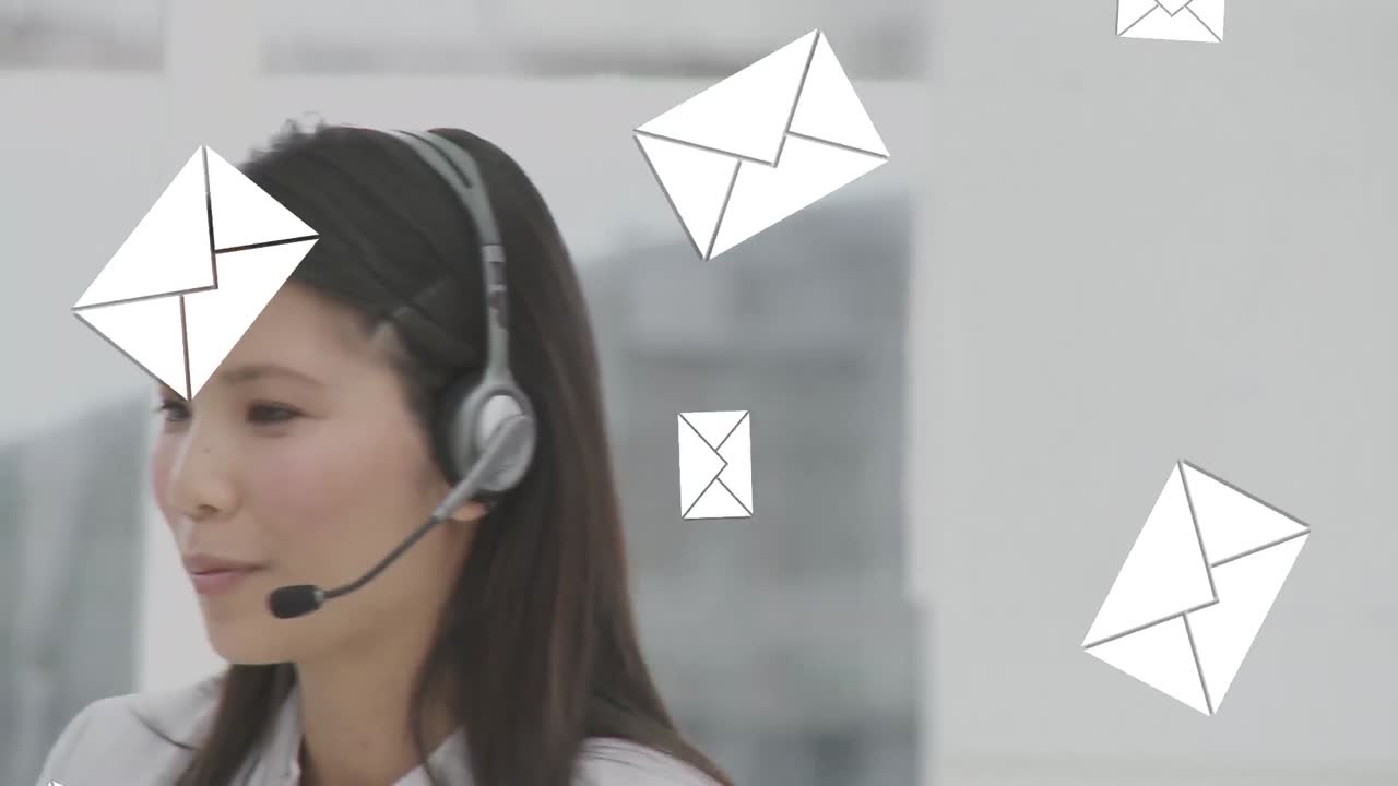 Icone di messaggistica che cadono su operatrice del servizio clienti asiatica che parla al telefono con auricolare in ufficio.