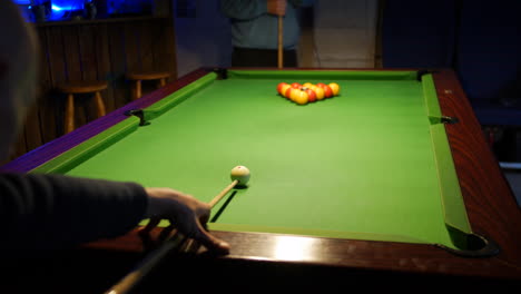 a man breaking the balls in a game of pool