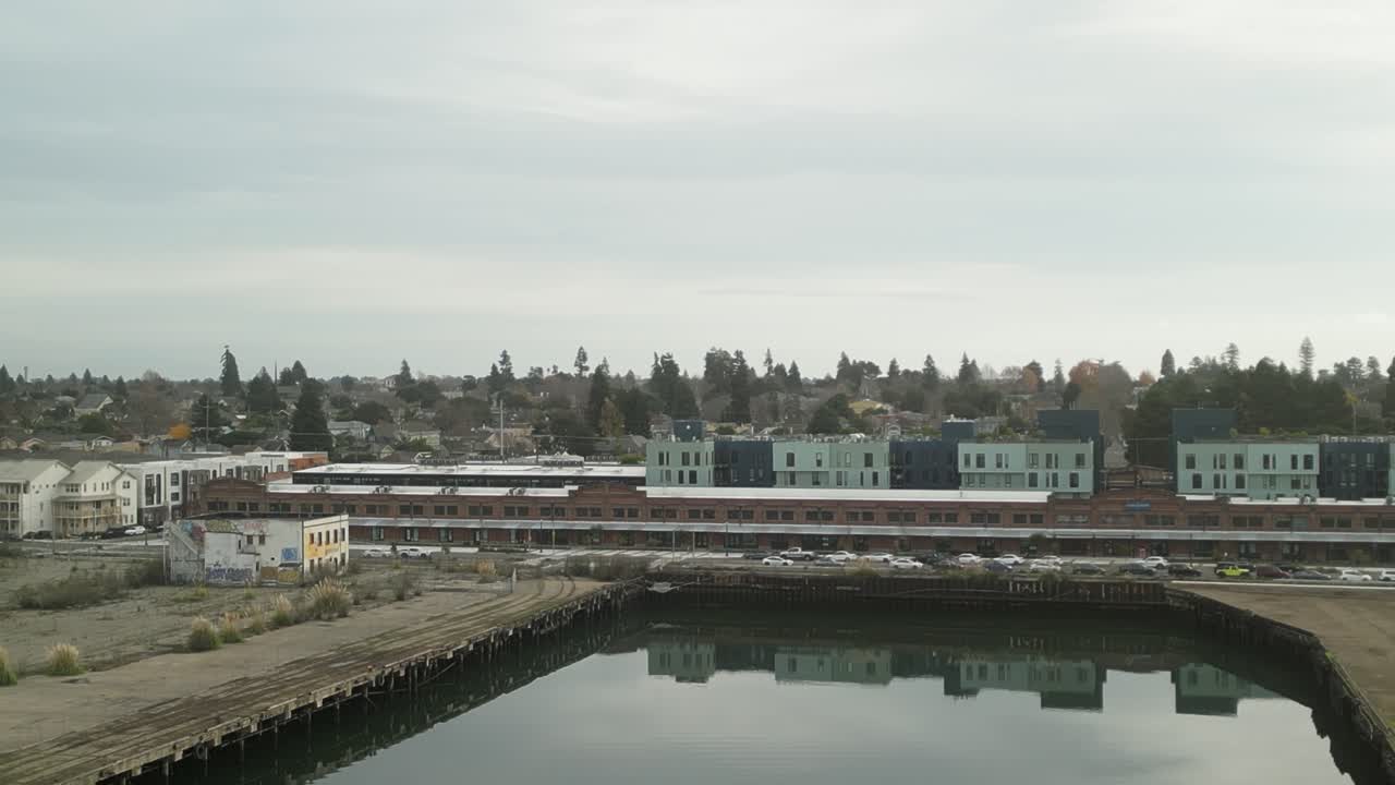 A tranquil drone view of Mariner Square, capturing the essence of Alameda's waterfront life with boats and clear skies.