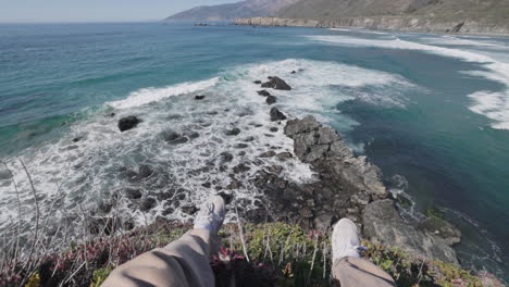 pov sitting on the edge of a cliff, looking out on the coast and ocean